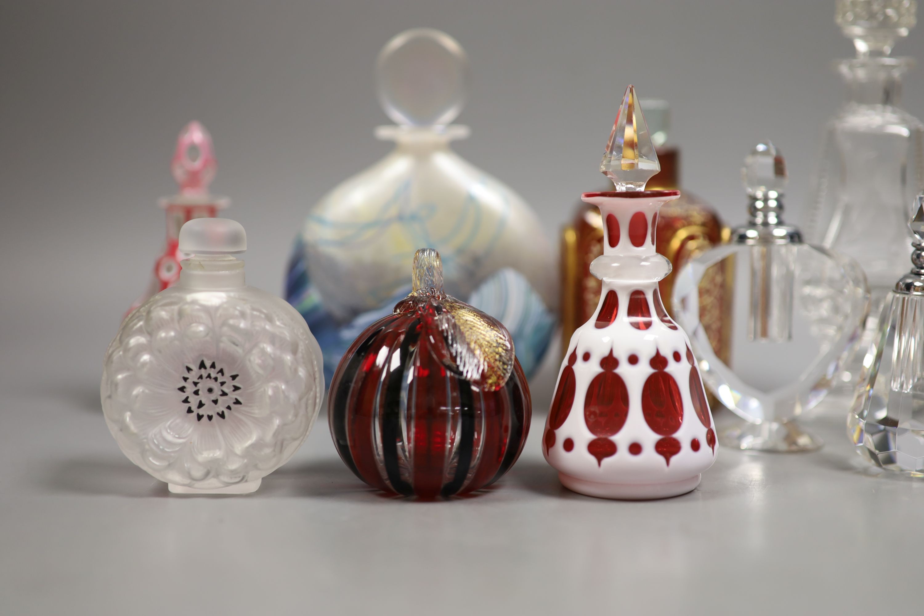 A collection of various glass scent bottles including a Lalique flower scent bottle and Bohemian examples, tallest 20.5cm
